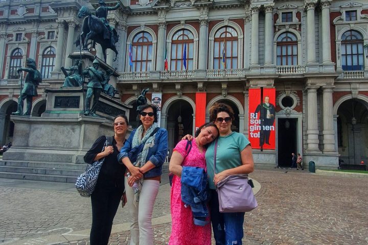 a group of people standing in front of a stone building