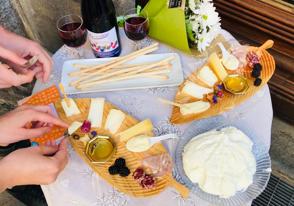 a person sitting at a table with a plate of food and cheese