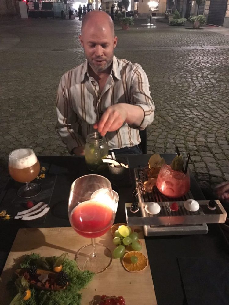 a man sitting at a table with wine glasses