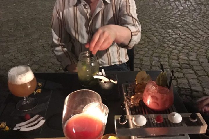 a man sitting at a table with wine glasses