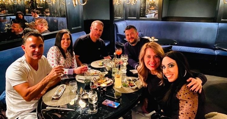 a group of people sitting at a table posing for the camera