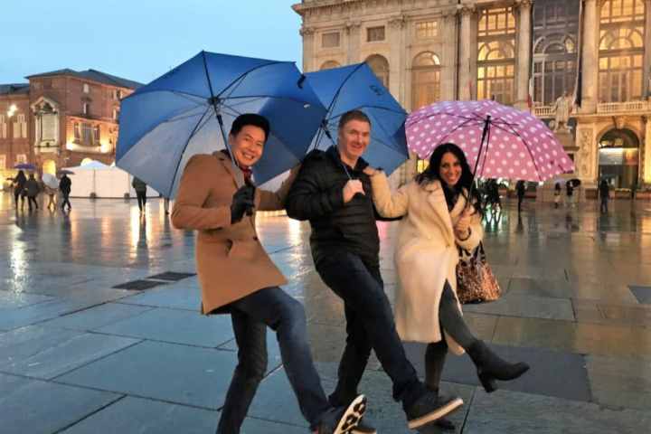 a woman walking down a sidewalk holding an umbrella