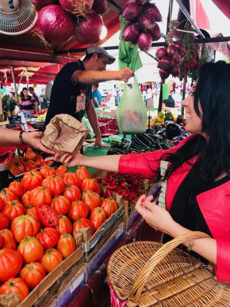 a group of people sitting at a fruit stand