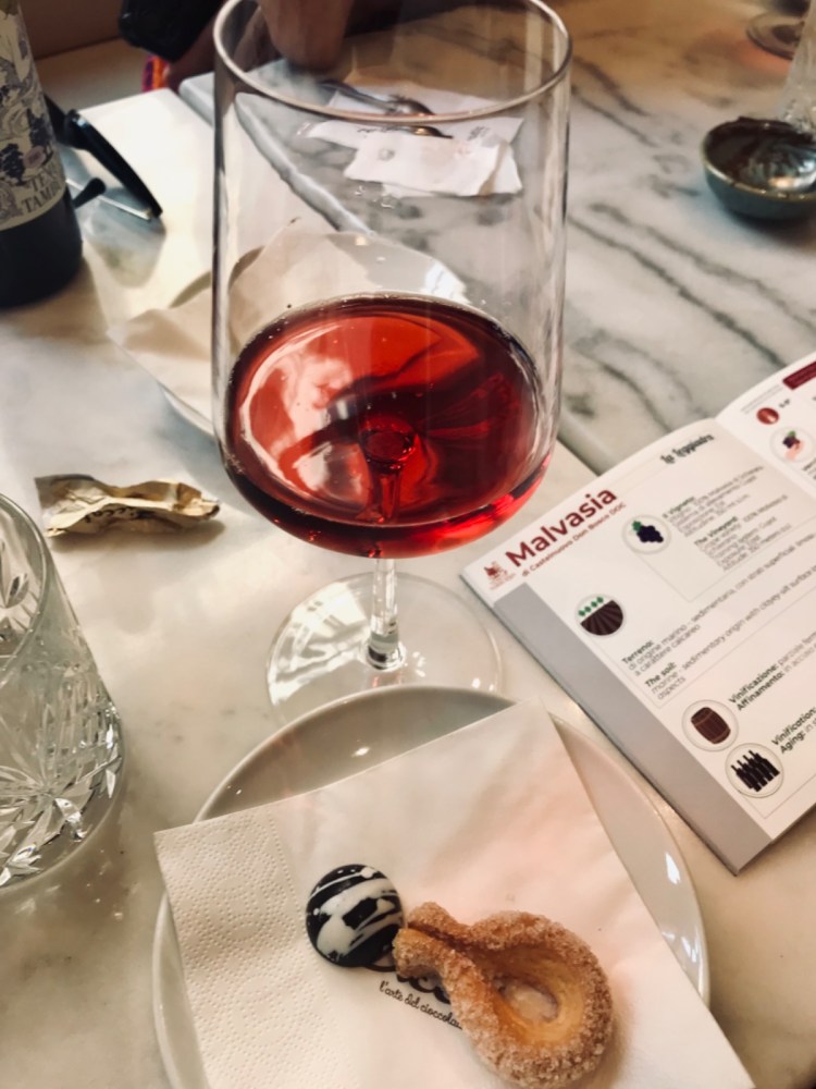 a plate of food and glasses of wine on a table