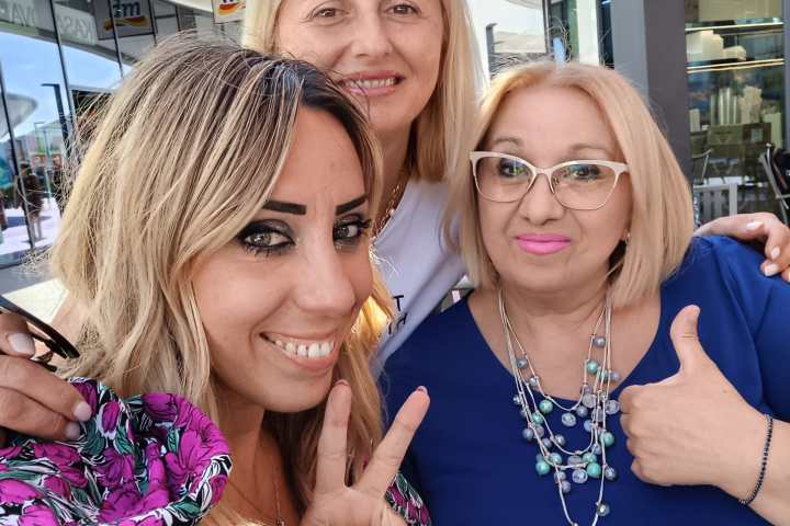 a woman standing in front of a group of people posing for the camera