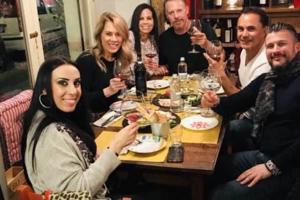 a group of people sitting at a table with wine glasses