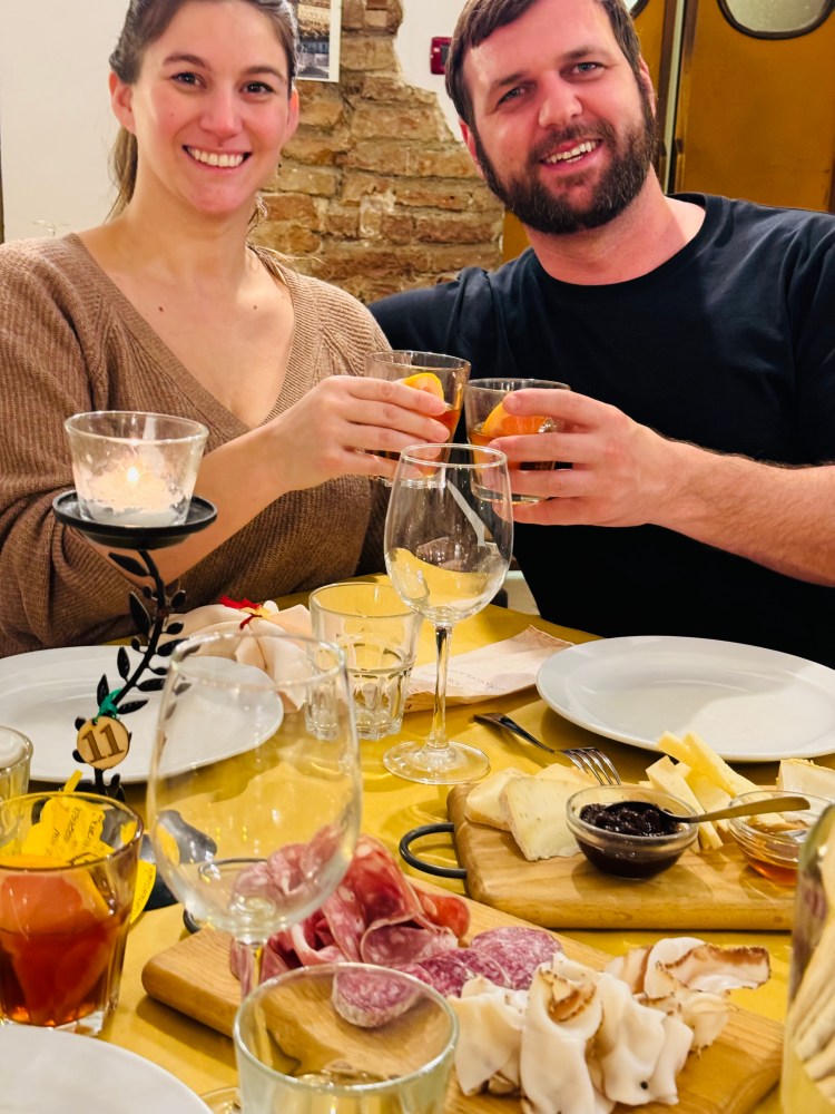 a man and a woman sitting at a table with food and drinks