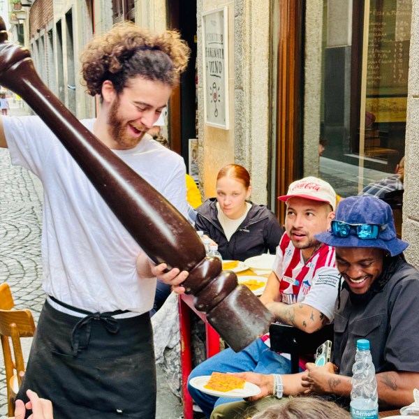 a group of people standing in front of a cake