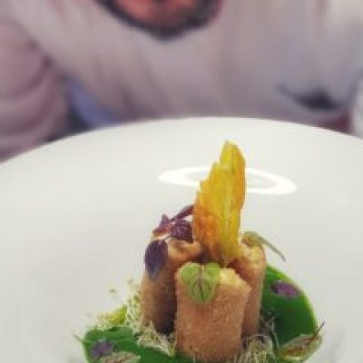 a person sitting at a table with a plate of food