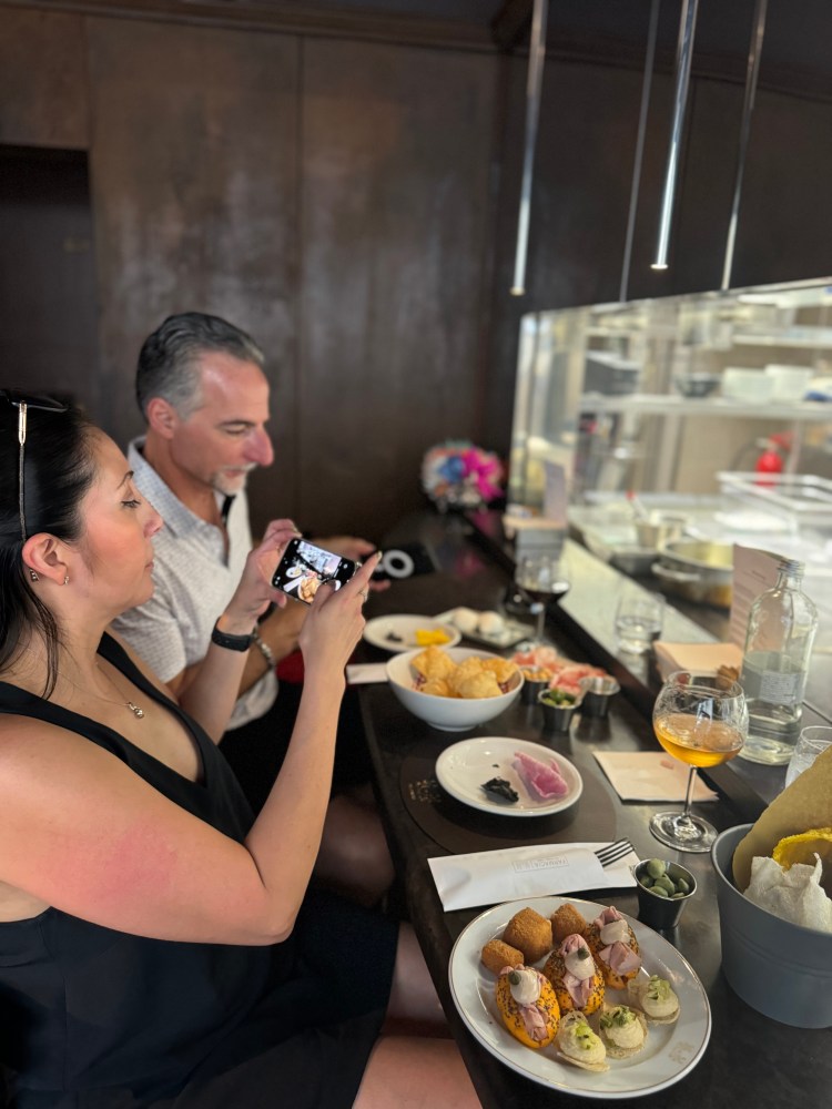 a man and a woman sitting at a table with a plate of food