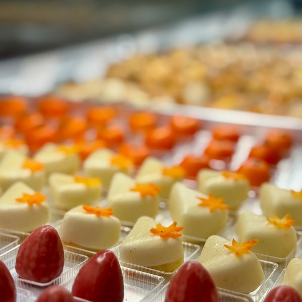 Assorted desserts with red and white toppings in clear trays, arranged in rows.