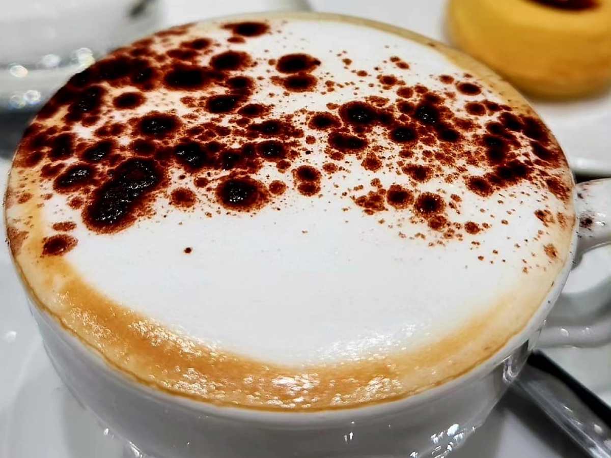 a piece of cake on a plate next to a cup of coffee