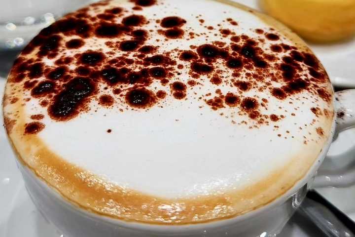 a piece of cake on a plate next to a cup of coffee