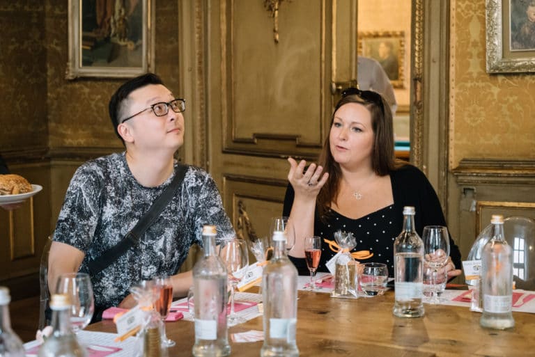 a person sitting at a table with wine glasses