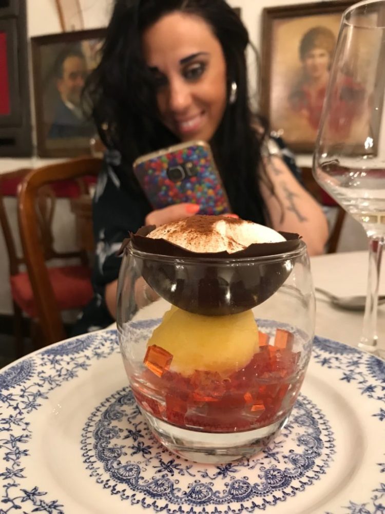 a person sitting at a table with a plate of food