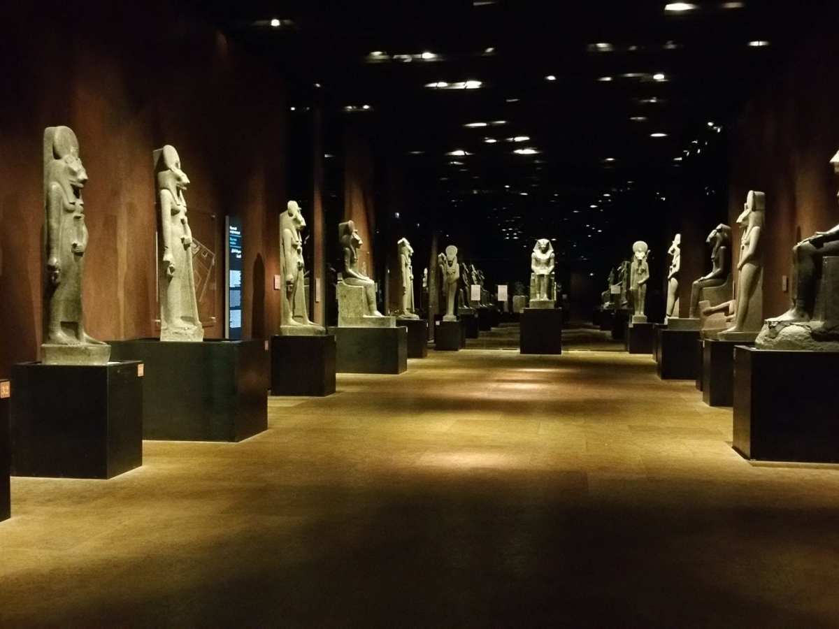 a room filled with furniture and vase with Museo Egizio in the background