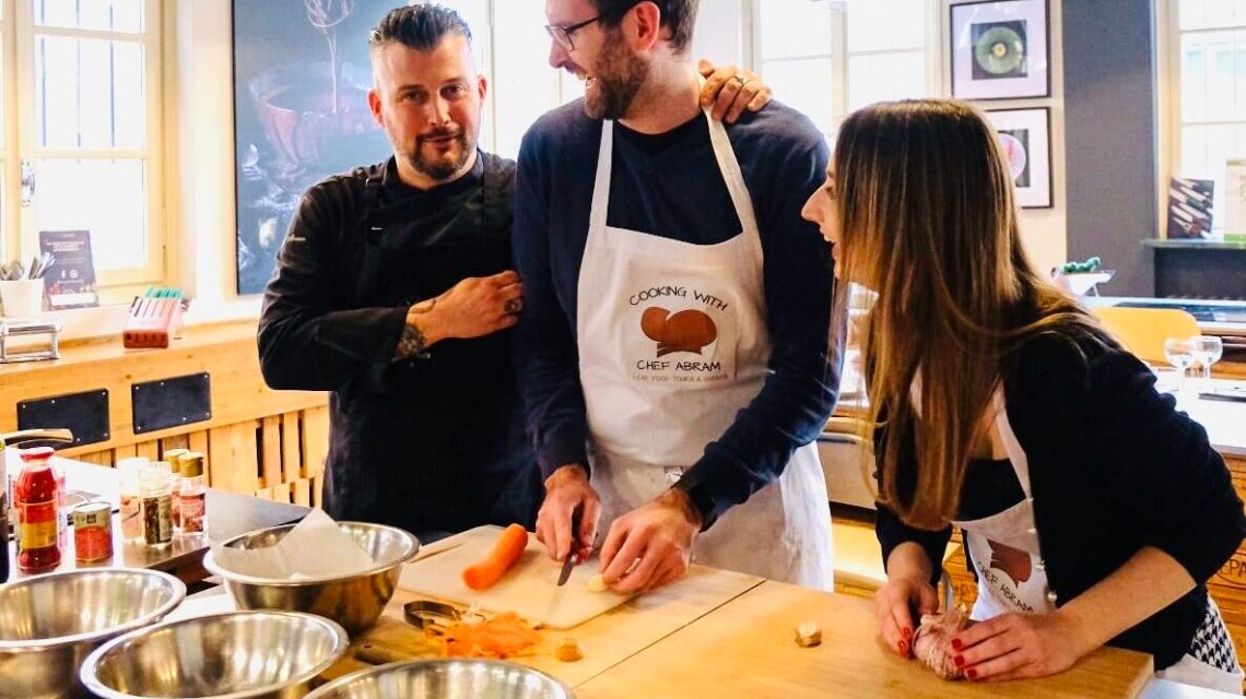 Cooking_classes_and_experiences_torino a person cooking in a kitchen preparing food