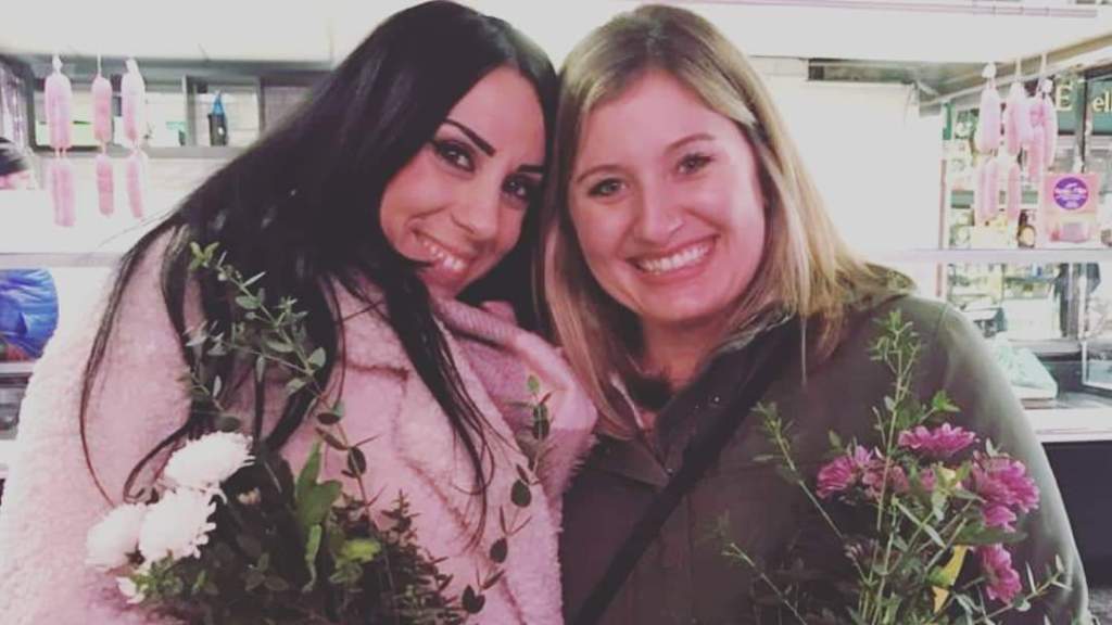 a woman posing in front of a flower