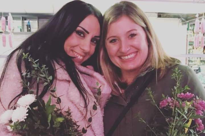 a woman posing in front of a flower