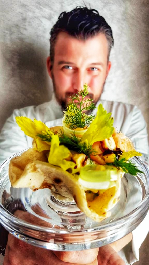 a man sitting at a table with a plate of food