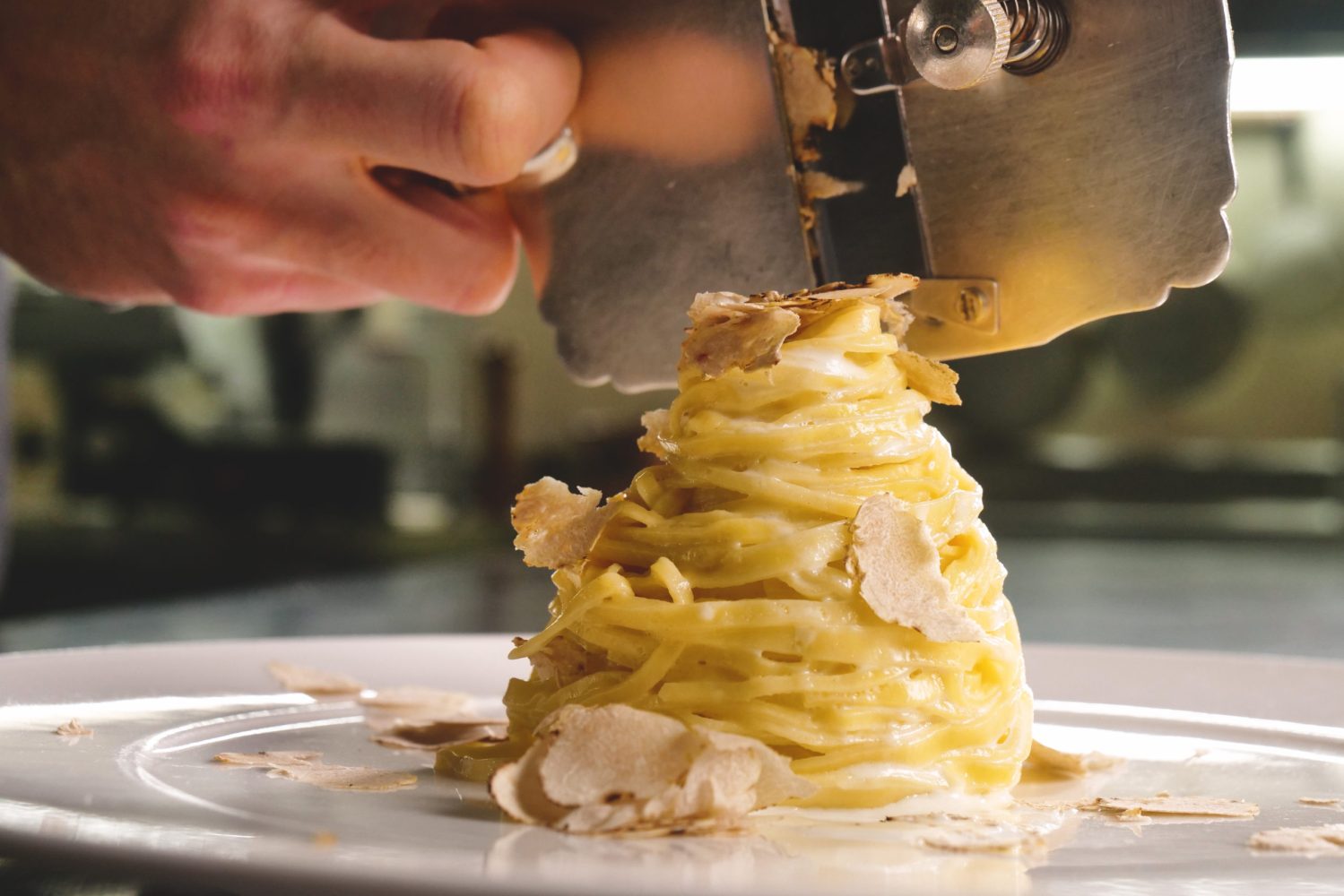 Shaving truffles on a plate of pasta