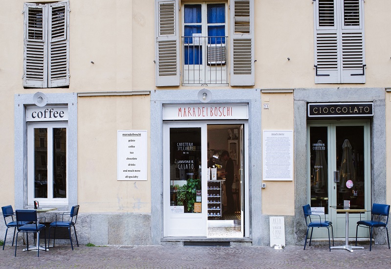 a person sitting on a bench in front of a building