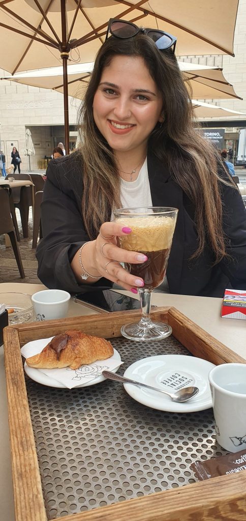 a woman sitting at a table with a cup of coffee