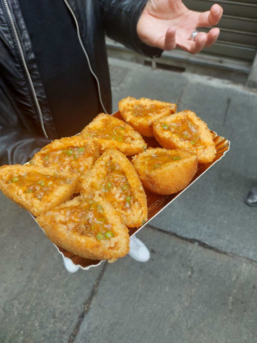 a person eating a arancino, rice ball