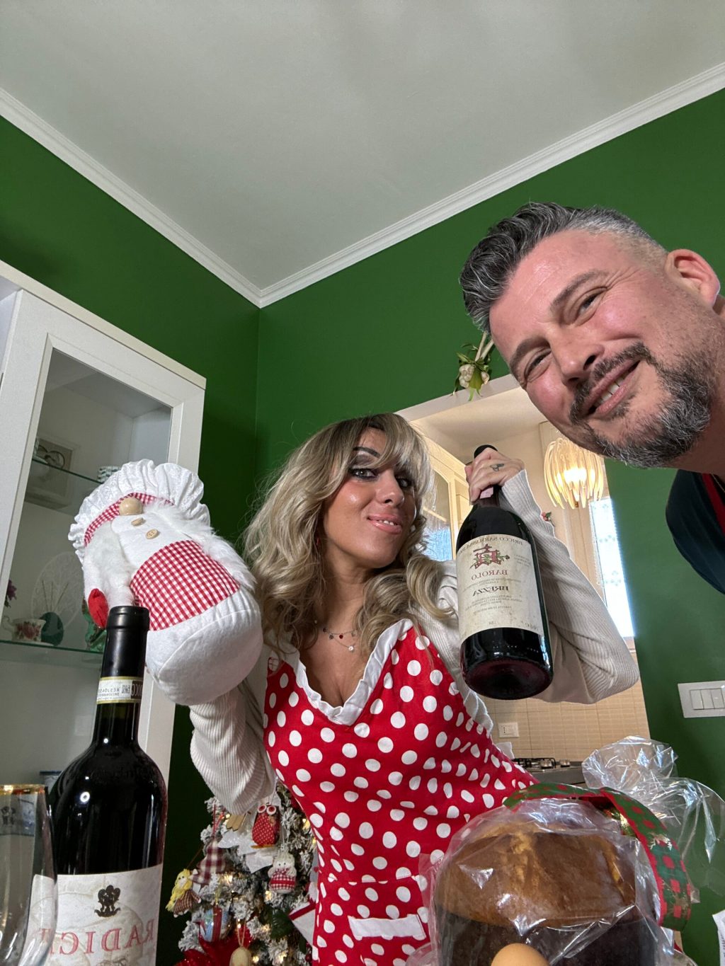 a man and a woman standing next to a bottle of wine