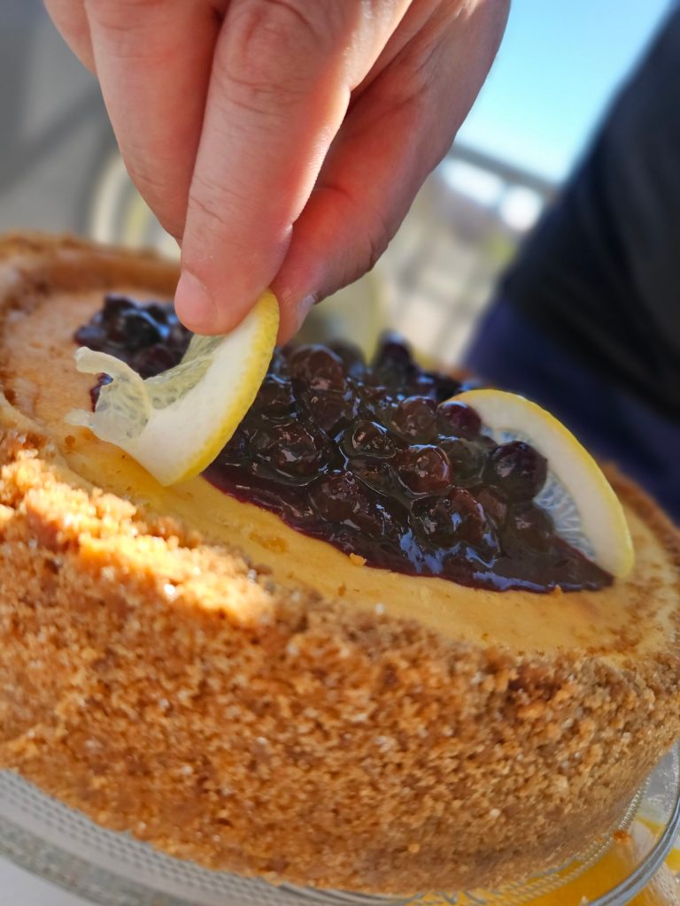 a hand holding a piece of cake on a plate