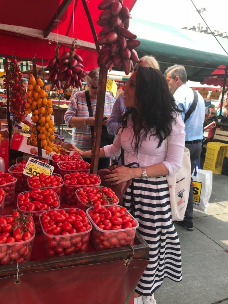 a group of people sitting at a fruit stand