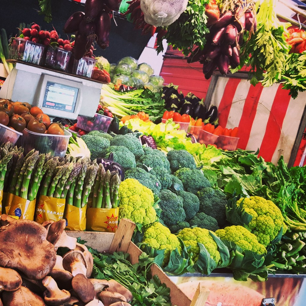 a group of people standing in front of a produce stand