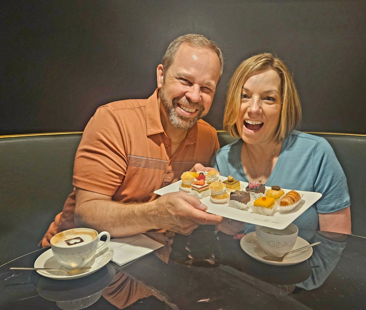 a man and a woman sitting at a table eating cake