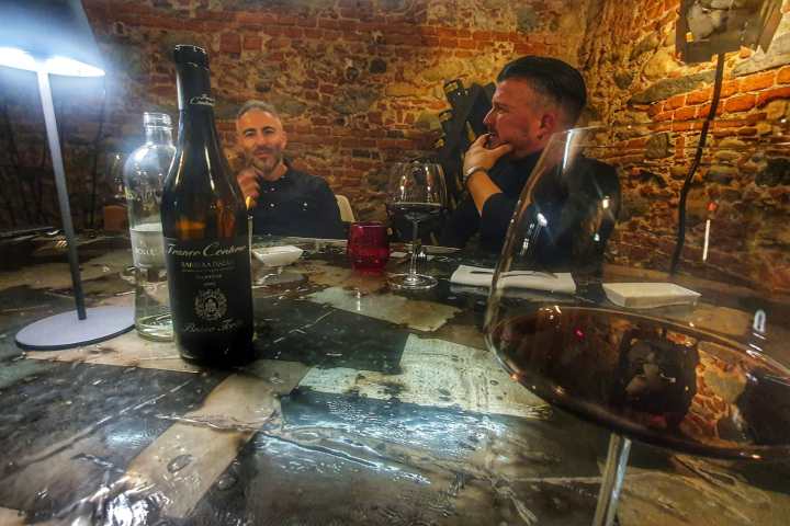 a person sitting at a table with a glass of wine