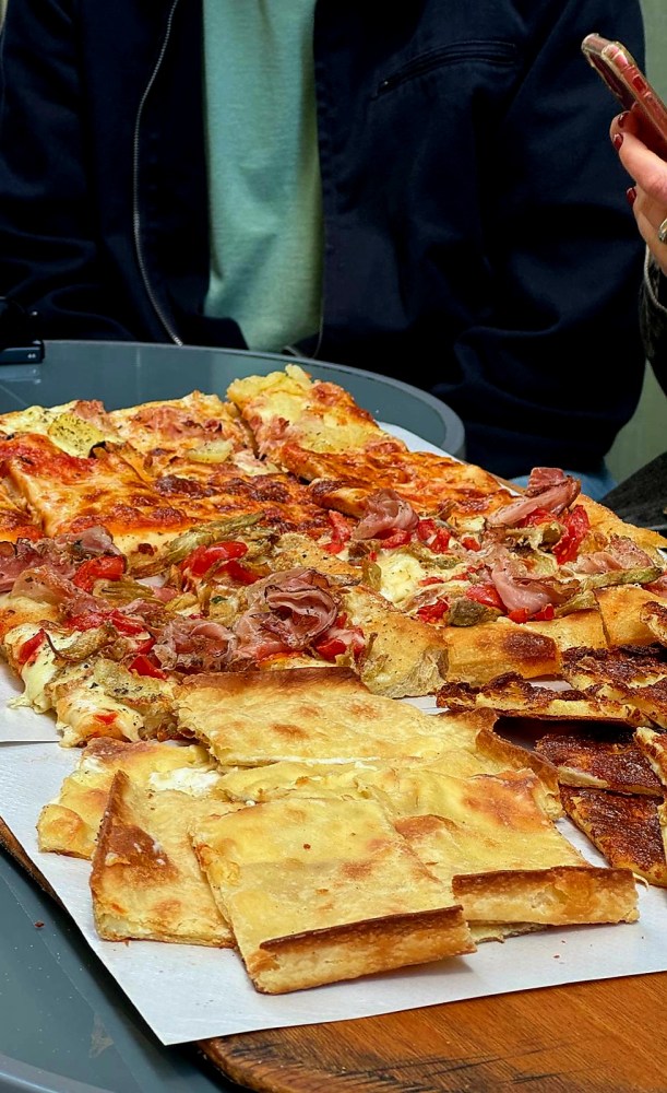 a person holding a slice of pizza