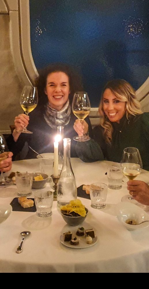 a group of people sitting at a table with wine glasses