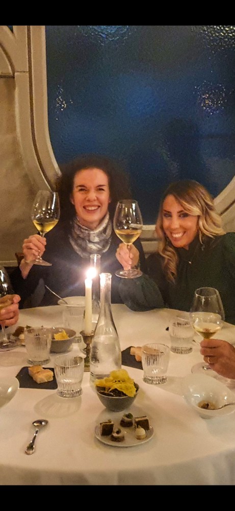 a group of people sitting at a table with wine glasses