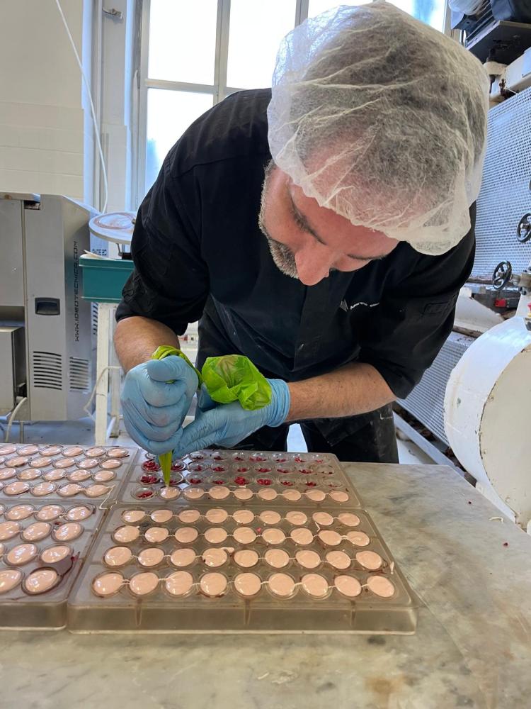 a man cutting chocolate on a table