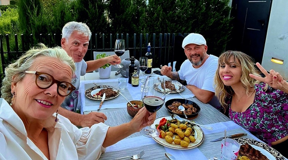 a group of people sitting at a table with a plate of food