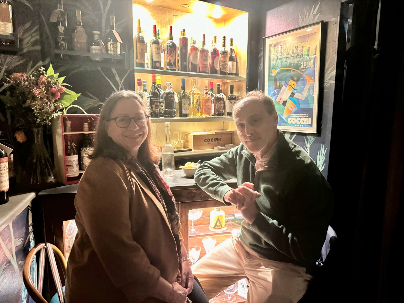 Two persons stending at a bar