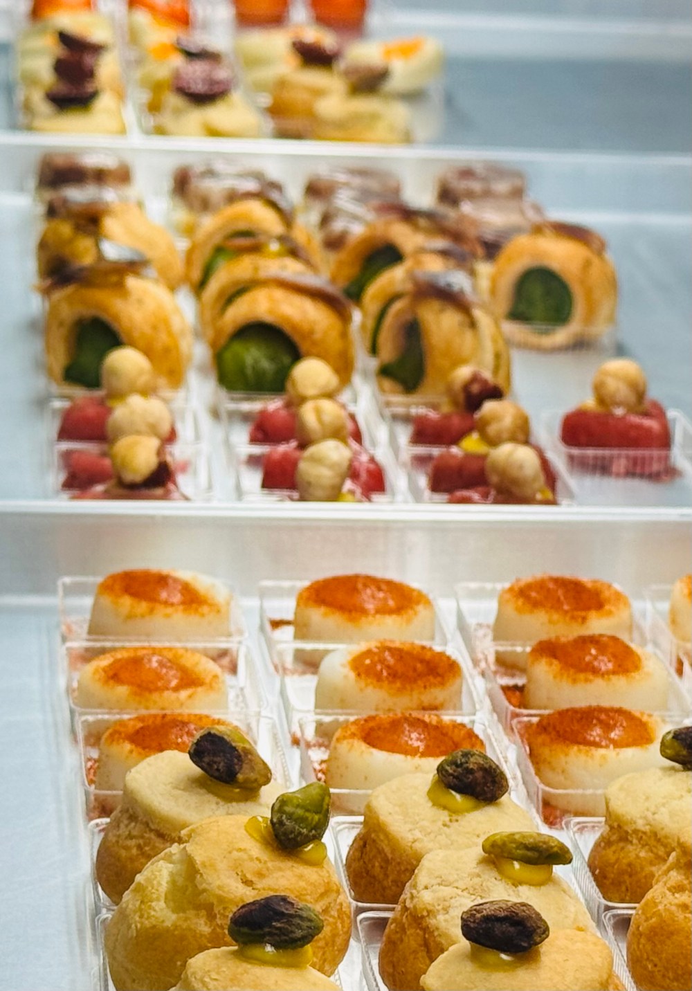 Rows of assorted pastries and desserts on trays