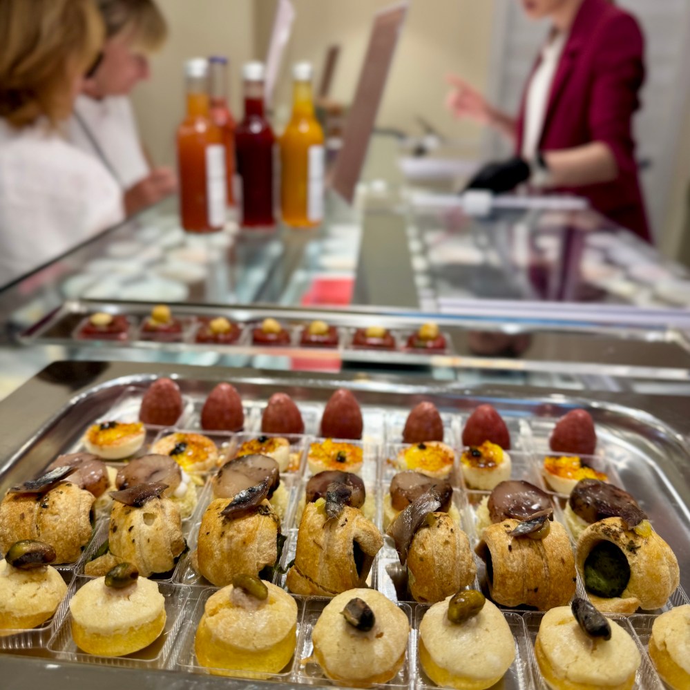 Display of assorted pastries and sauces on a reflective surface.